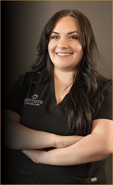 Portrait of Monica, a dental hygienist at Dentists of Hinsdale Lake, with a warm and inviting smile, clad in a professional black uniform, representing her passion for patient education in dental health and disease prevention.